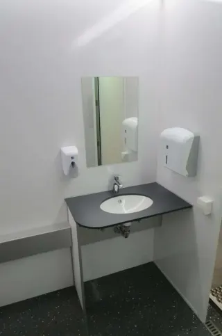 Toilet met steunbeugels en opklapbare armsteunen in de MIVA-container