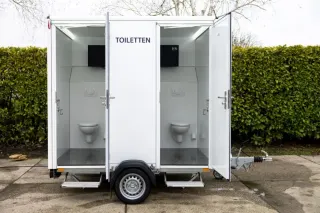 Toiletwagen DL111 buiten opgesteld met zicht op de deuren