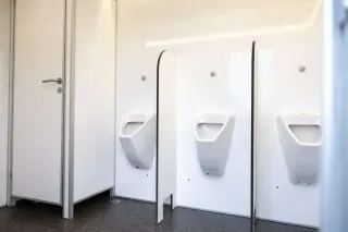 Drie urinoirs in de herenruimte van de toiletwagen DL313