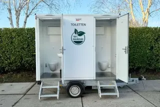 Vacuüm toiletwagen DL111 met twee open deuren op een verharde ondergrond