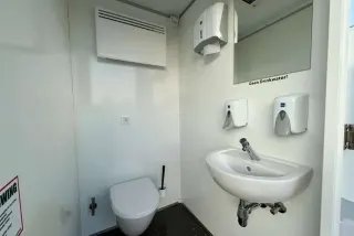 Toiletruimte van de DL111 met wandtoilet, wastafel en zeepdispenser