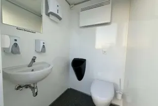 Herenruimte van de DL111 met wastafel, toilet en urinoir